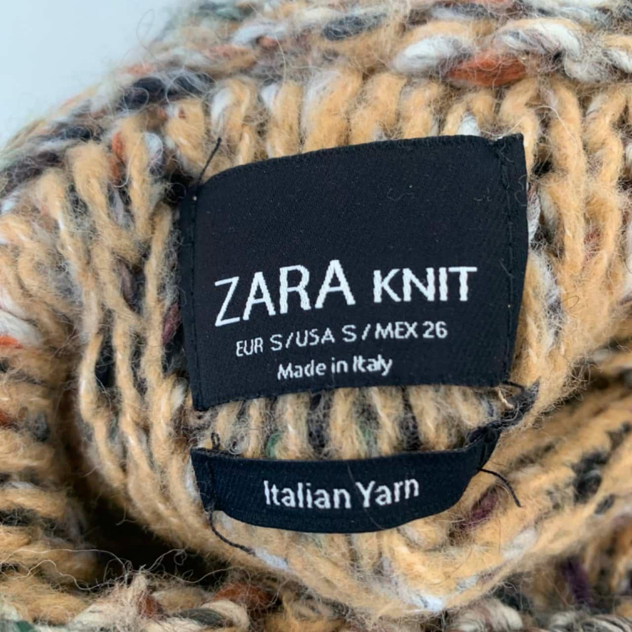 A Zara blouse label indicating Italian yarn and “Made in Italy,” reflecting how final finishing may occur in Italy while production happens elsewhere, such as Türkiye (Photo by Salvos Store).