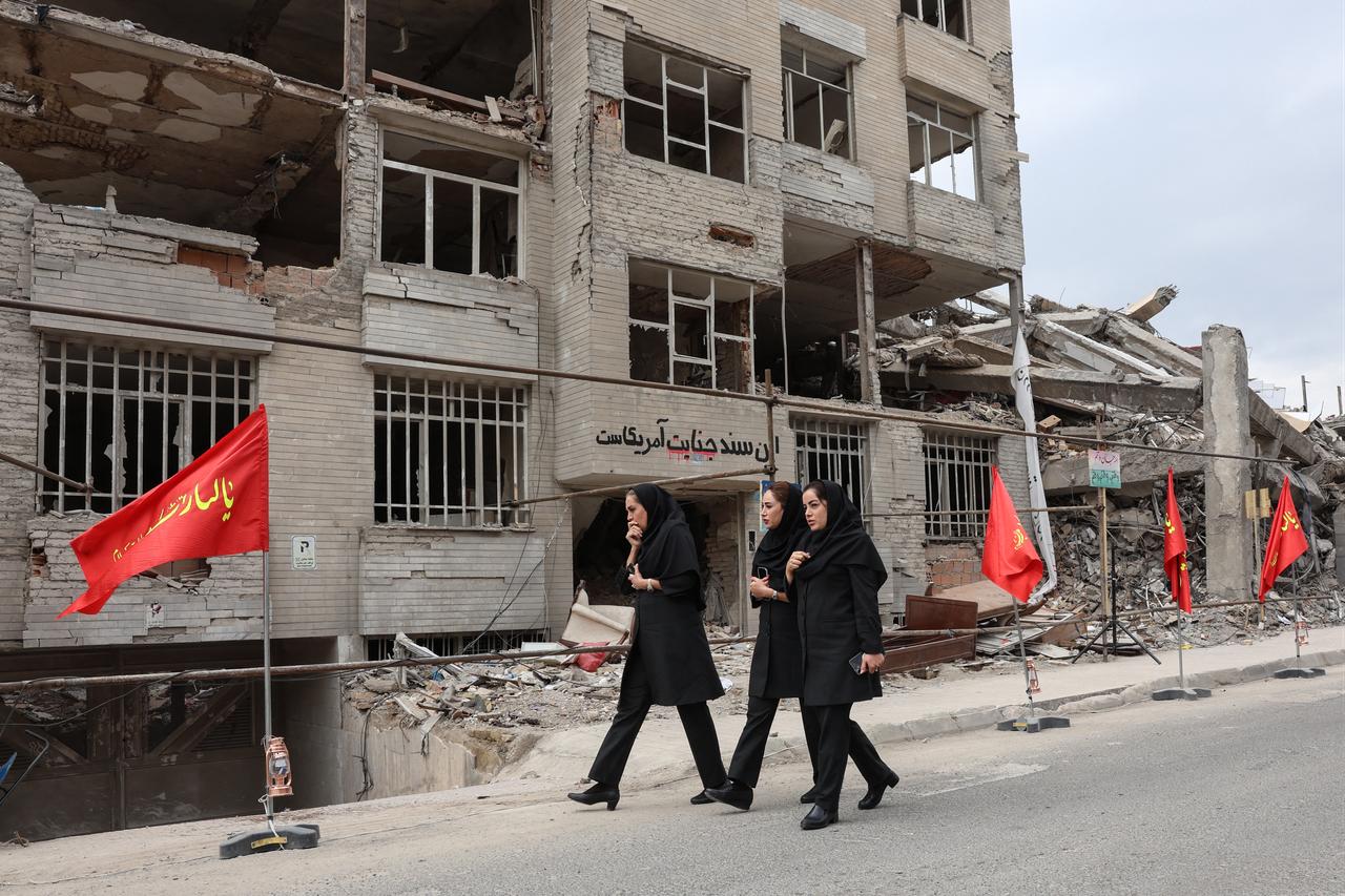 Iranian women walk past a residential building destroyed in a US-Israeli airstrike, in Tehran, Iran on April 13, 2026. (AFP Photo)