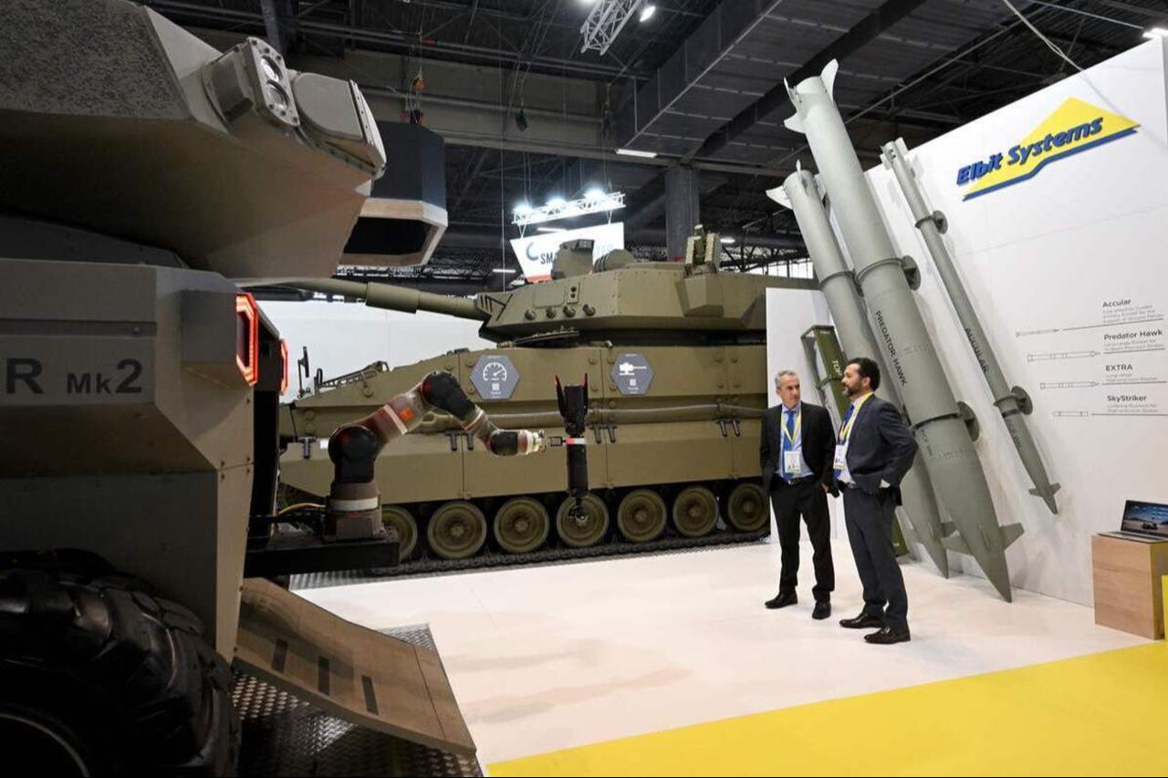 Israeli defense technology company Elbit Systems staff stand on the booth at the Eurosatory international land and airland defense and security trade fair, in Villepinte, Paris, on June 13, 2022. (AFP Photo)