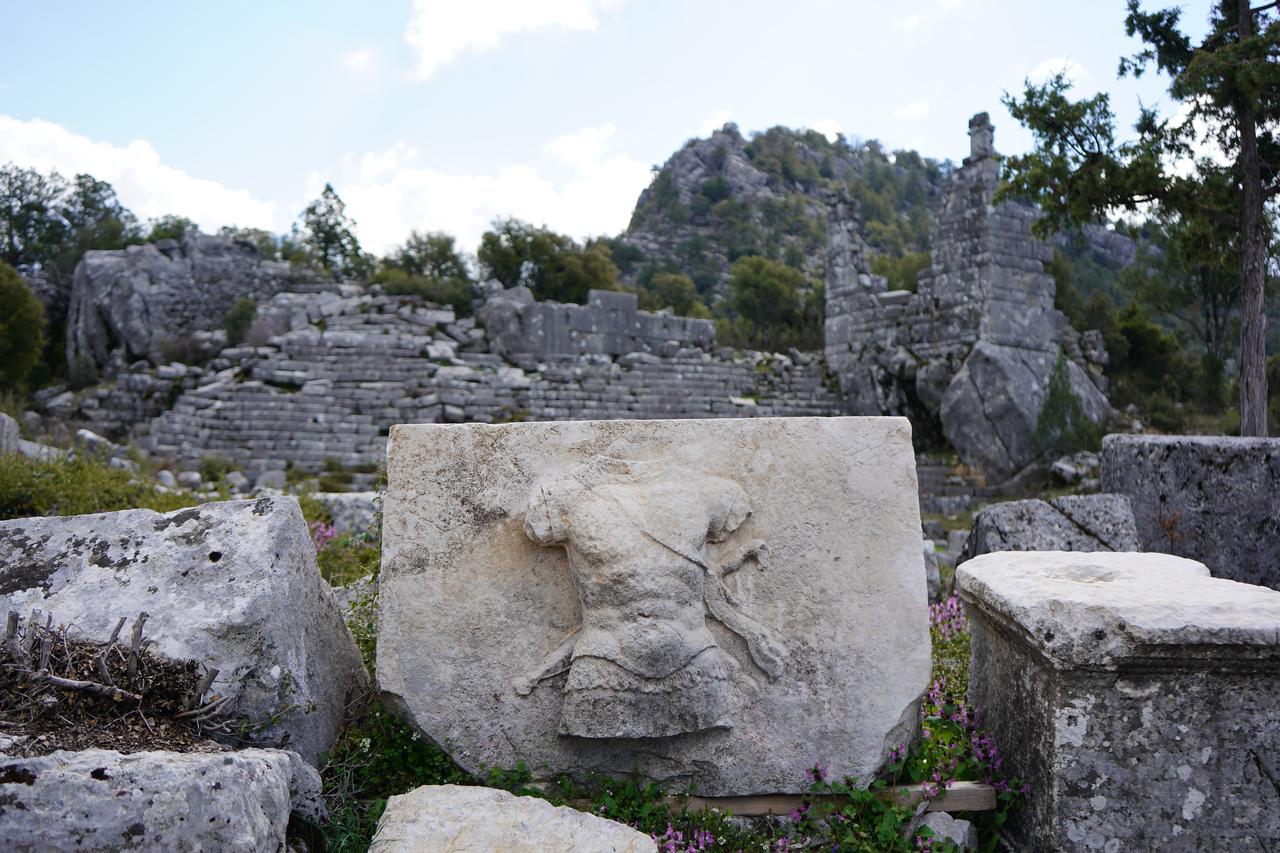 A relief depicting a torso carved in stone is displayed among the ruins of the ancient city of Adada, where ongoing archaeological excavations reveal a continuous settlement and advanced administrative structure spanning 17 centuries in Sutculer district of Isparta, Türkiye, April 9, 2026. (AA Photo)