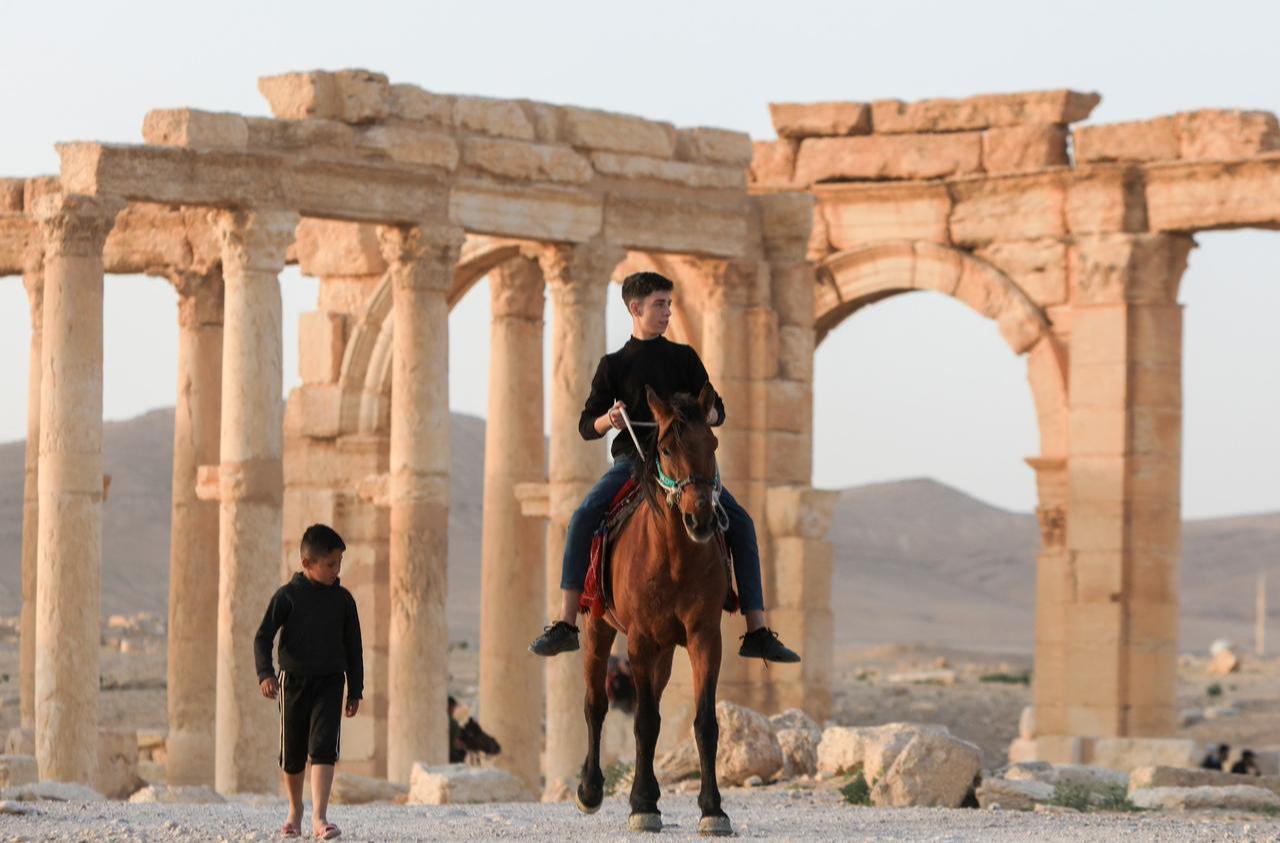 Syrians, including children, spend time among the ruins of the Ancient City of Palmyra, which was listed as a World Heritage Site by UNESCO in 1980 and destroyed by the terrorist organization Daesh in 2015, are seen in Homs Governorate, Syria, April 4, 2025. (AA Photo)