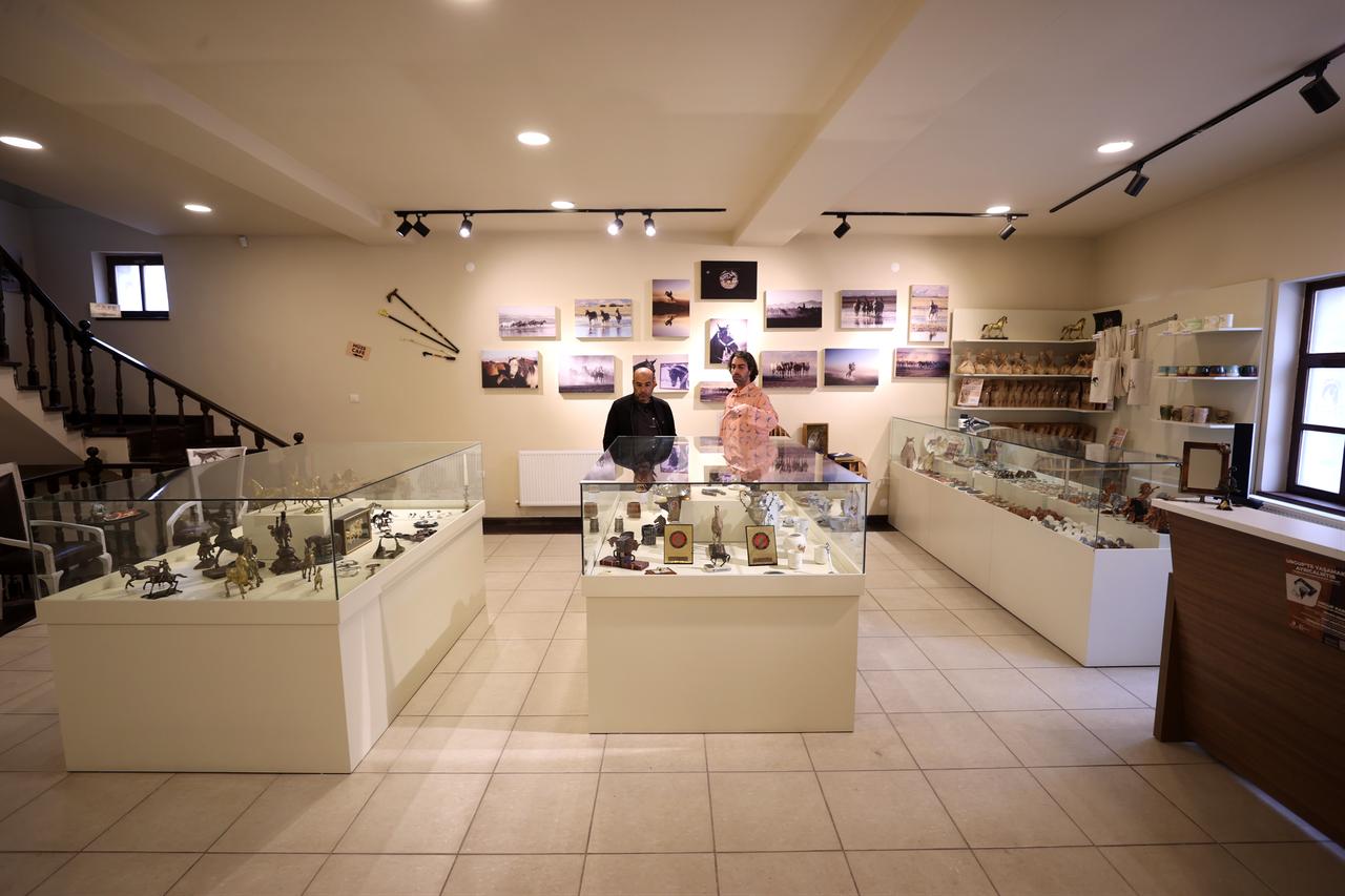 Visitors walk through exhibition halls featuring horse-themed sculptures and objects at the museum in Urgup, Cappadocia, Türkiye, April 15, 2026. (AA Photo)