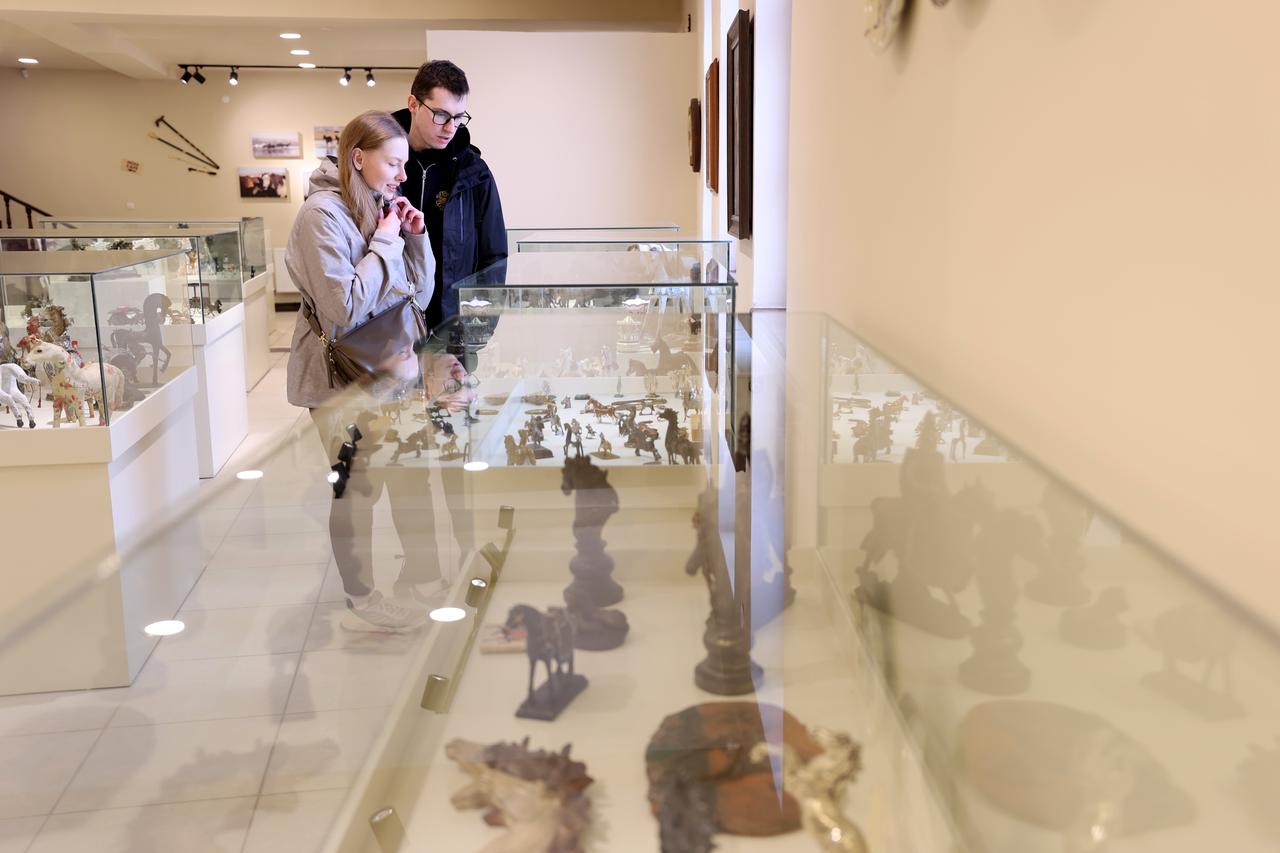 Visitors examine horse-themed artworks displayed inside the Erhan Ayata Beautiful Horses Museum in Urgup, Cappadocia, Türkiye, April 15, 2026. (AA Photo)