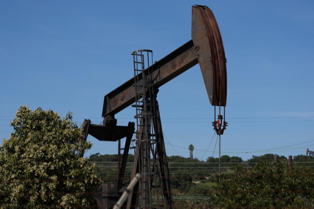 Crude returns below $100 per barrel, gold hits highest in a month