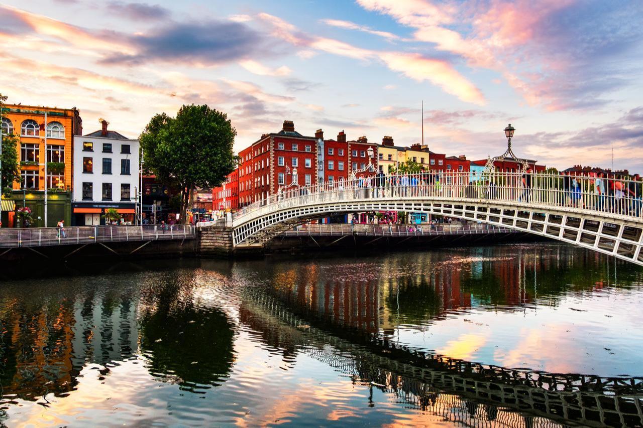 Pedestrians crossing the Liffey Bridge into Temple Bar at sunset, Dublin, Ireland, accessed on April 15, 2026. (Adobe Stock Photo)