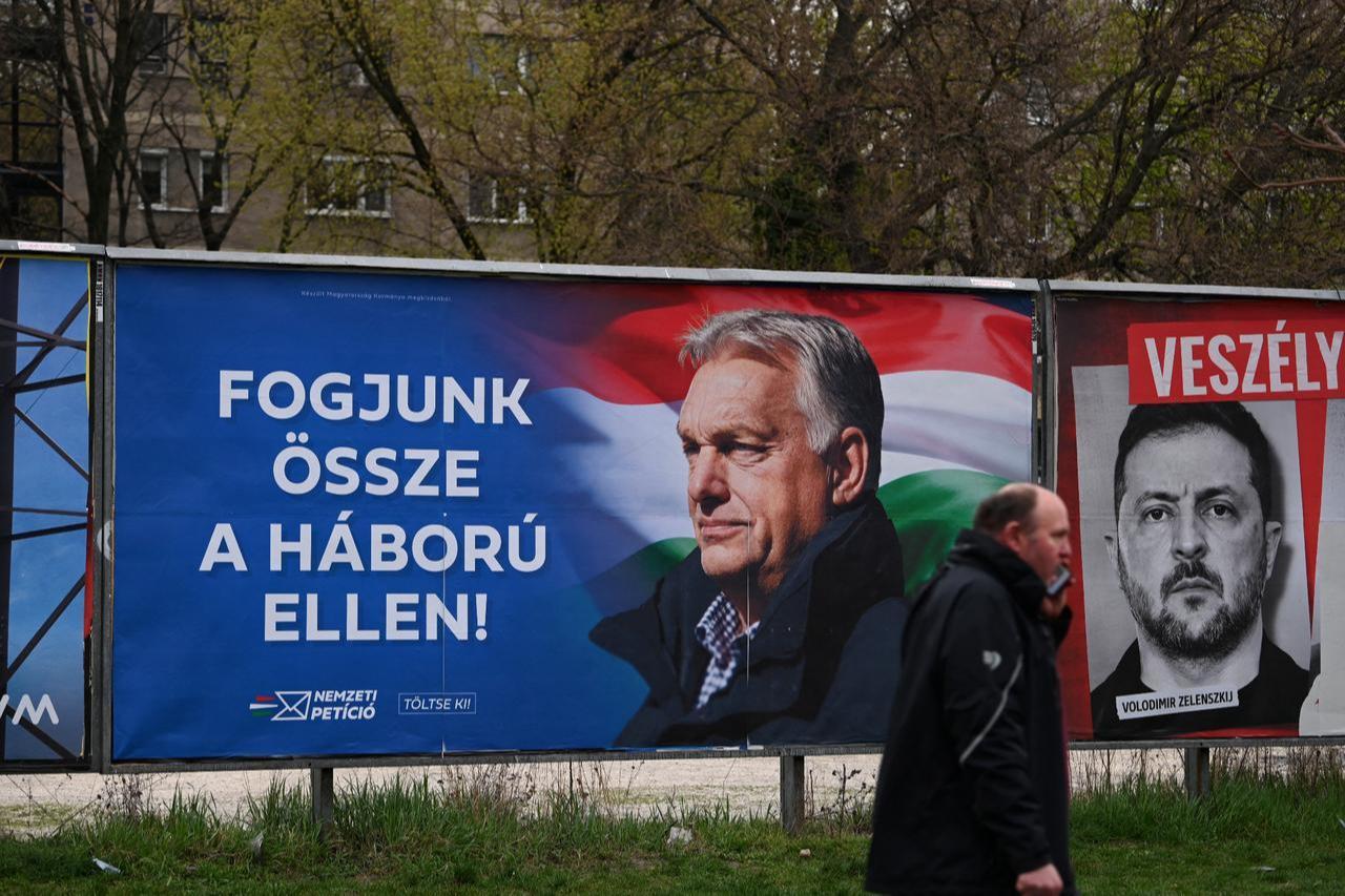 A billboard (L) featuring Hungarian Prime Minister Viktor Orban with the text reading, 'Let's get together against the war' stands next to another with a portrait of Ukraine's President Volodymyr Zelenskyy (R) with the text reading, 'Hazard' are seen in Budapest's 3rd district on March 27, 2026. (AFP Photo)