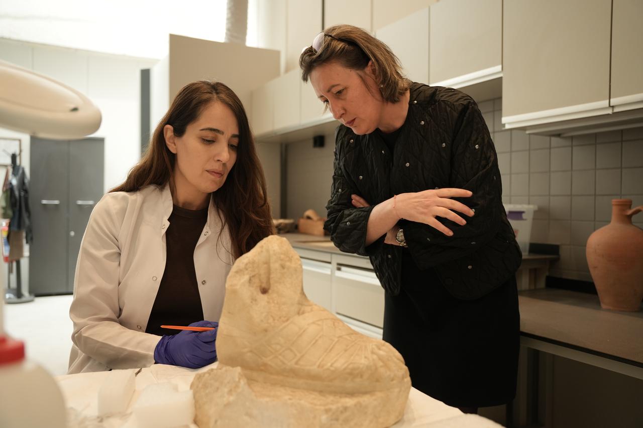 A conservation expert and Troy Museum Director Sinem Duzgoren (R) work on a sculpture from the Troy Museum collection ahead of its transfer to Rome, Canakkale, Türkiye, April 15, 2026. (AA Photo)