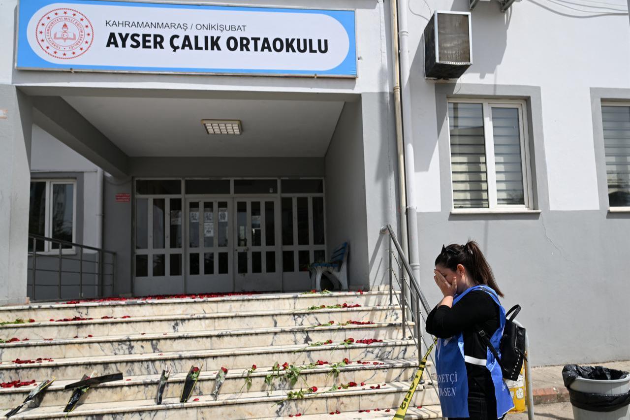 A woman reacts in front of the stairs, where roses are displayed, leading to the entrance of the Ayser Calik college ahead of the funerals for nine victims killed in a school shooting in the southern province of Kahramanmaras, April 16, 2026. (AFP Photo)
