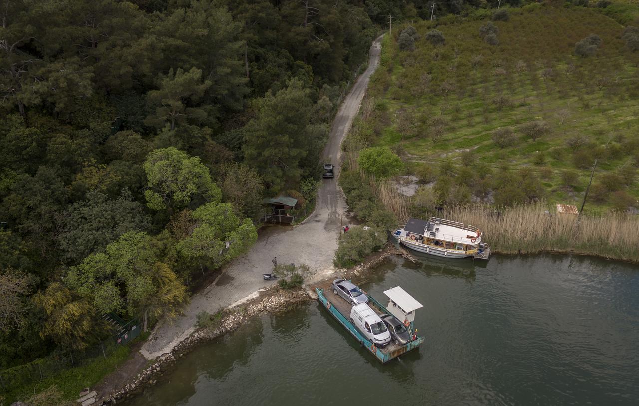 An aerial view shows the ferry dock and rural road network linking Dalyan and Candir neighborhoods along the Dalyan Canal in Mugla, Türkiye. (AA Photo)