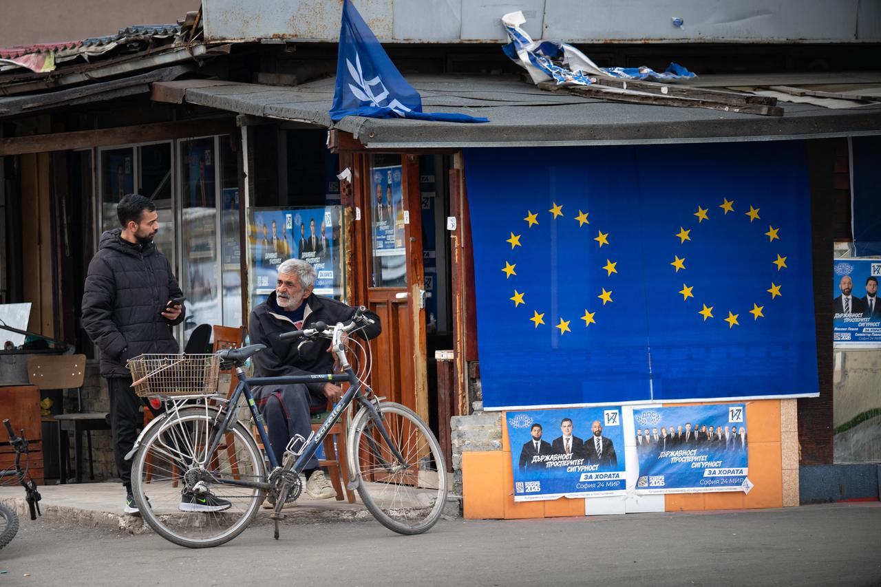 Local residents talk next to electoral posters of Movement for Rights and Freedoms (MRF) - New Beginning party and European flags in Sofia on April 13, 2026. (AFP Photo)