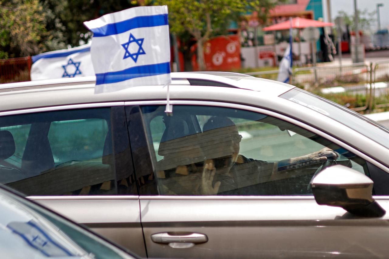 People drive along the central street in a car with an Israeli flag in the northern city of Kiryat Shmona, near the border with Lebanon, April 17, 2026. (AFP Photo)