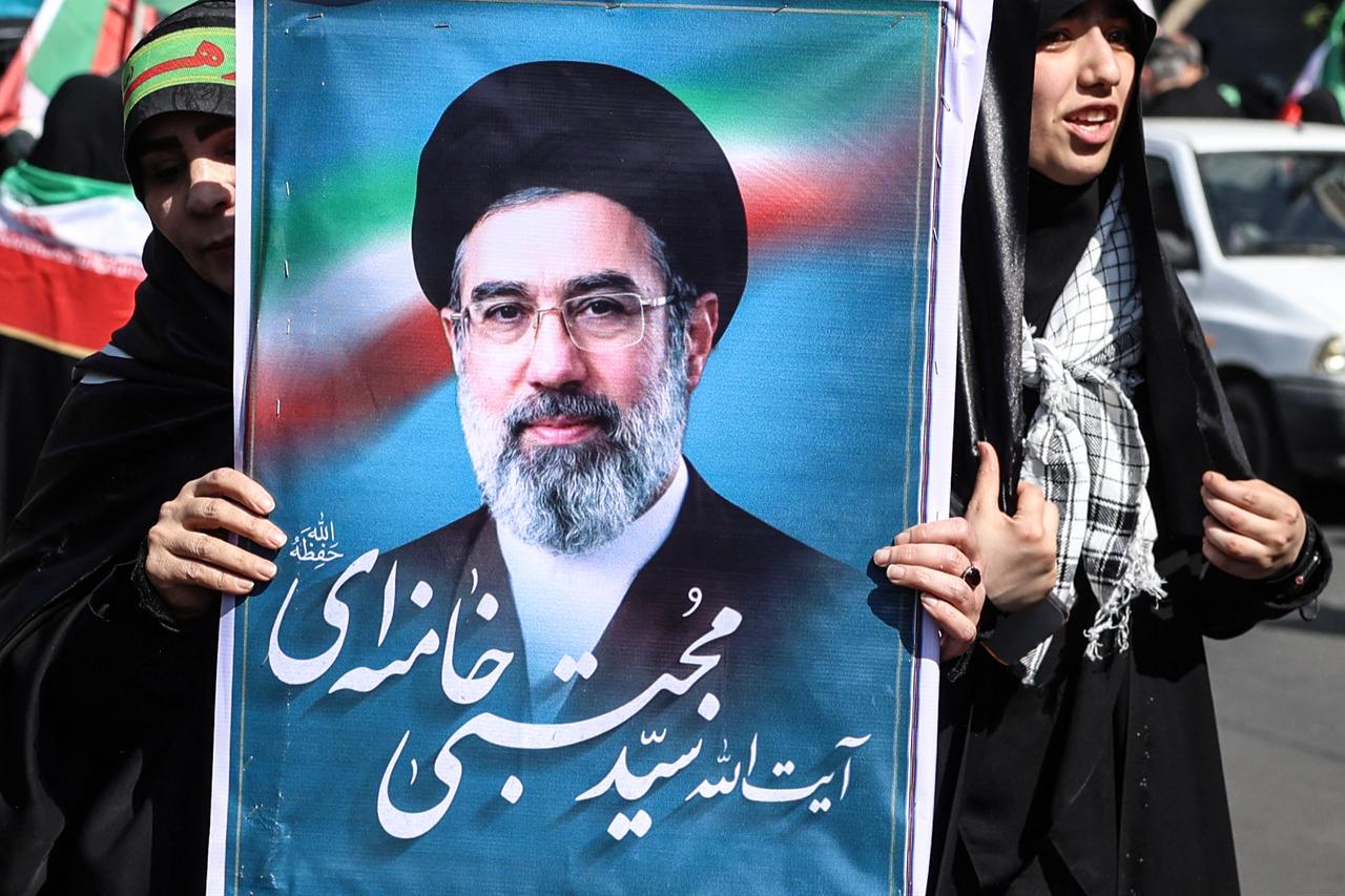 An Iranian woman holds up an image of Iran’s new supreme leader, Mojtaba Khamenei, as she takes part in a rally in Tehran on April 17, 2026. (AFP Photo)