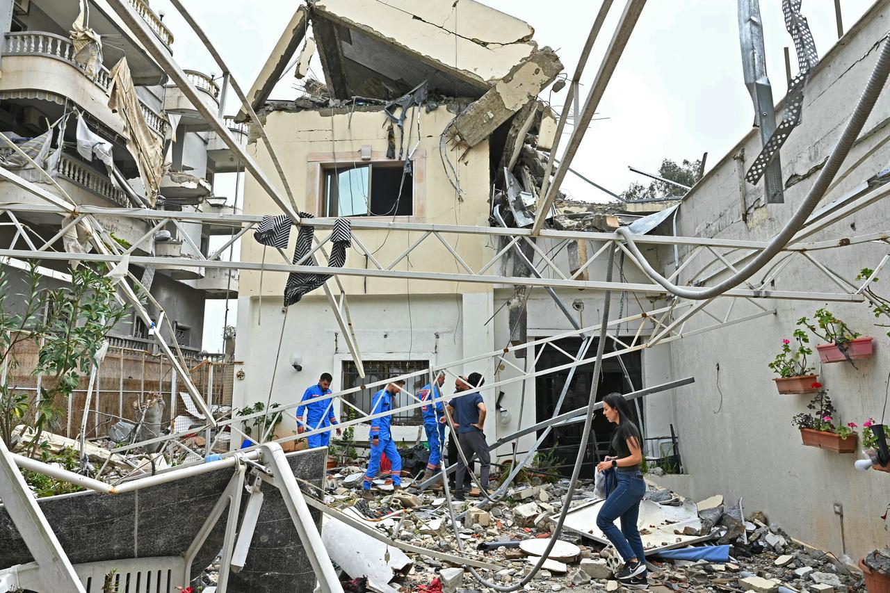 People inspect the rubble of a destroyed building upon their arrival back to the southern Lebanese city of Nabatieh on April 18, 2026. (AFP Photo)