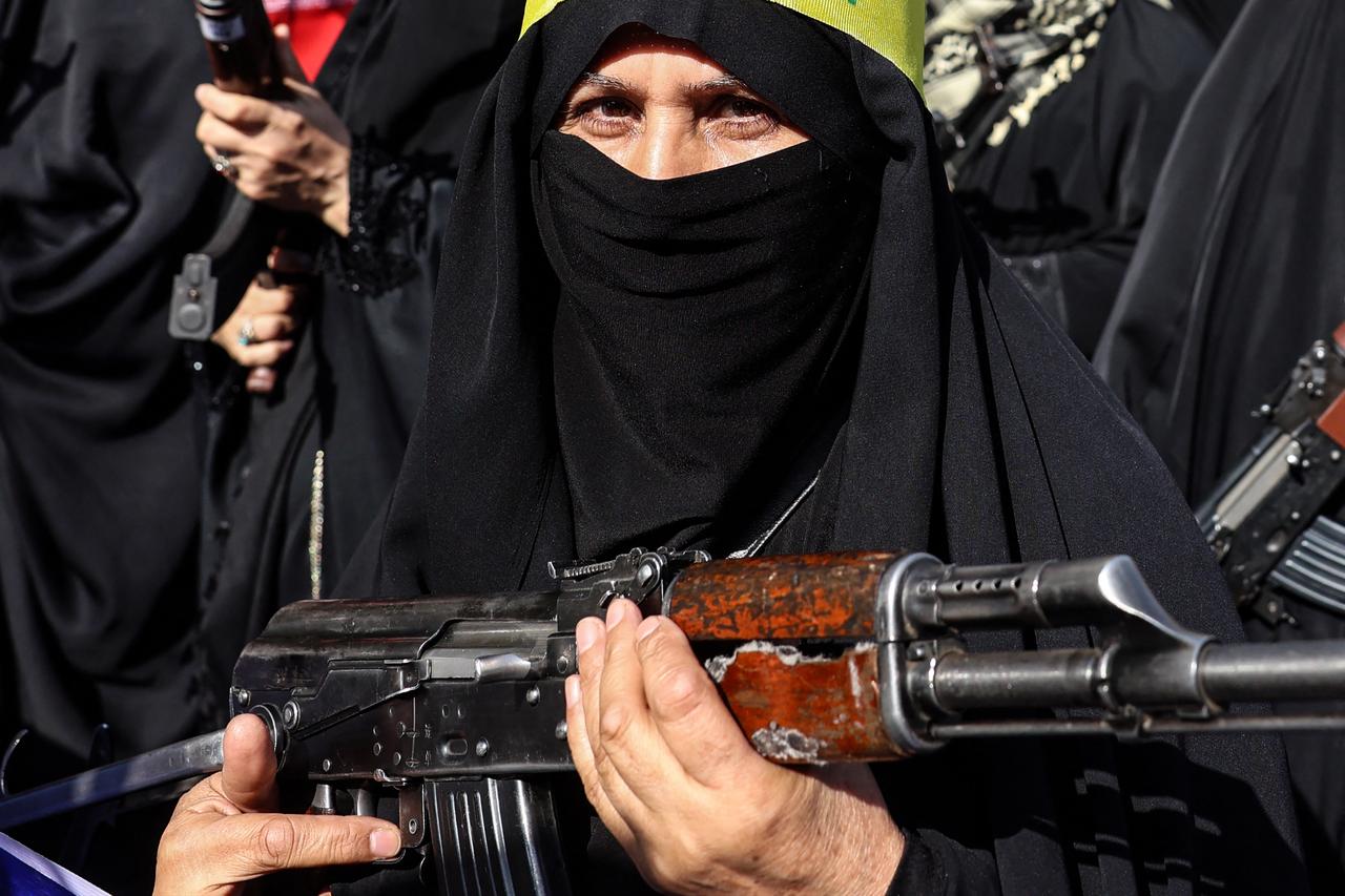 An Iranian woman brandishes a rifle during a rally dubbed “Sacrificed Girls” to pay tribute to women killed during the Middle East war in Tehran, April 17, 2026. (AFP Photo)