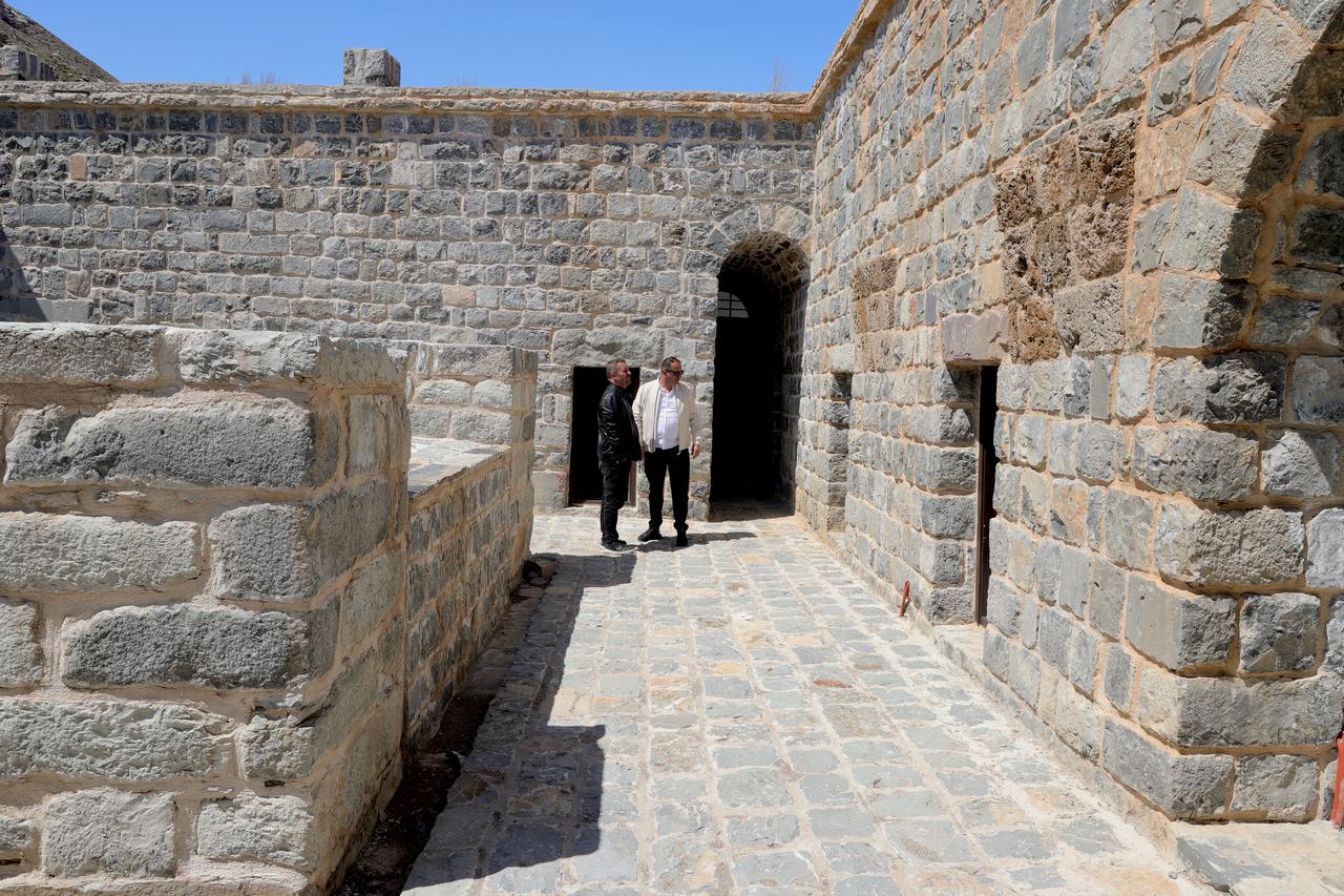 Visitors walk through the restored stone courtyard and arched entrance of the 466-year-old Zeynel Bey Madrasa in Hakkari, Türkiye. (AA Photo)