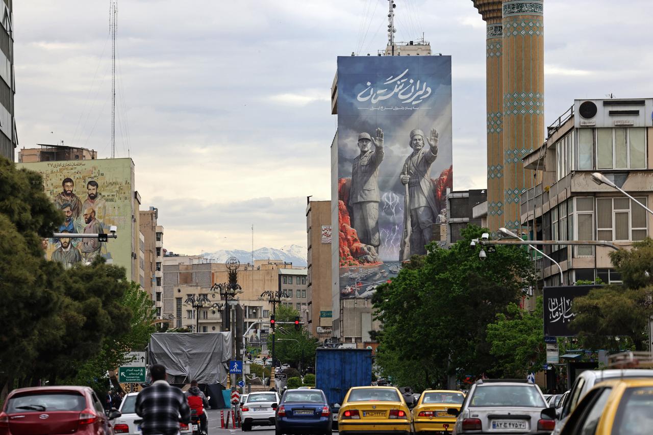 Commuters drive past a giant billboard referring to the 'Strait of Hormuz' along a busy street in Tehran on April 19, 2026. (AFP Photo)