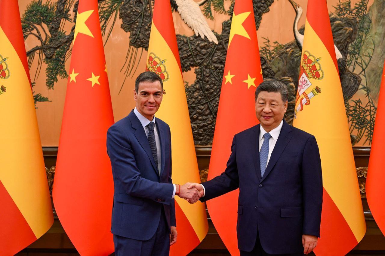 In this handout photo taken and released on April 14, 2026, shows China's President Xi Jinping (R) shaking hands with Spain's Prime Minister Pedro Sanchez in Beijing. (Photo by Borja Puig de la BELLACASA/LA MONCLOA/AFP)