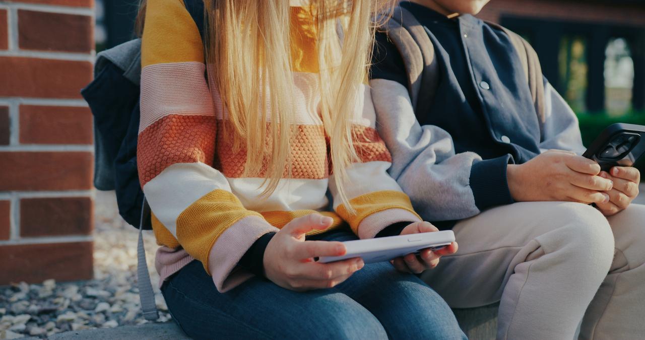 Children using smartphones highlighting their everyday use of digital devices. (Adobe Stock Photo)
