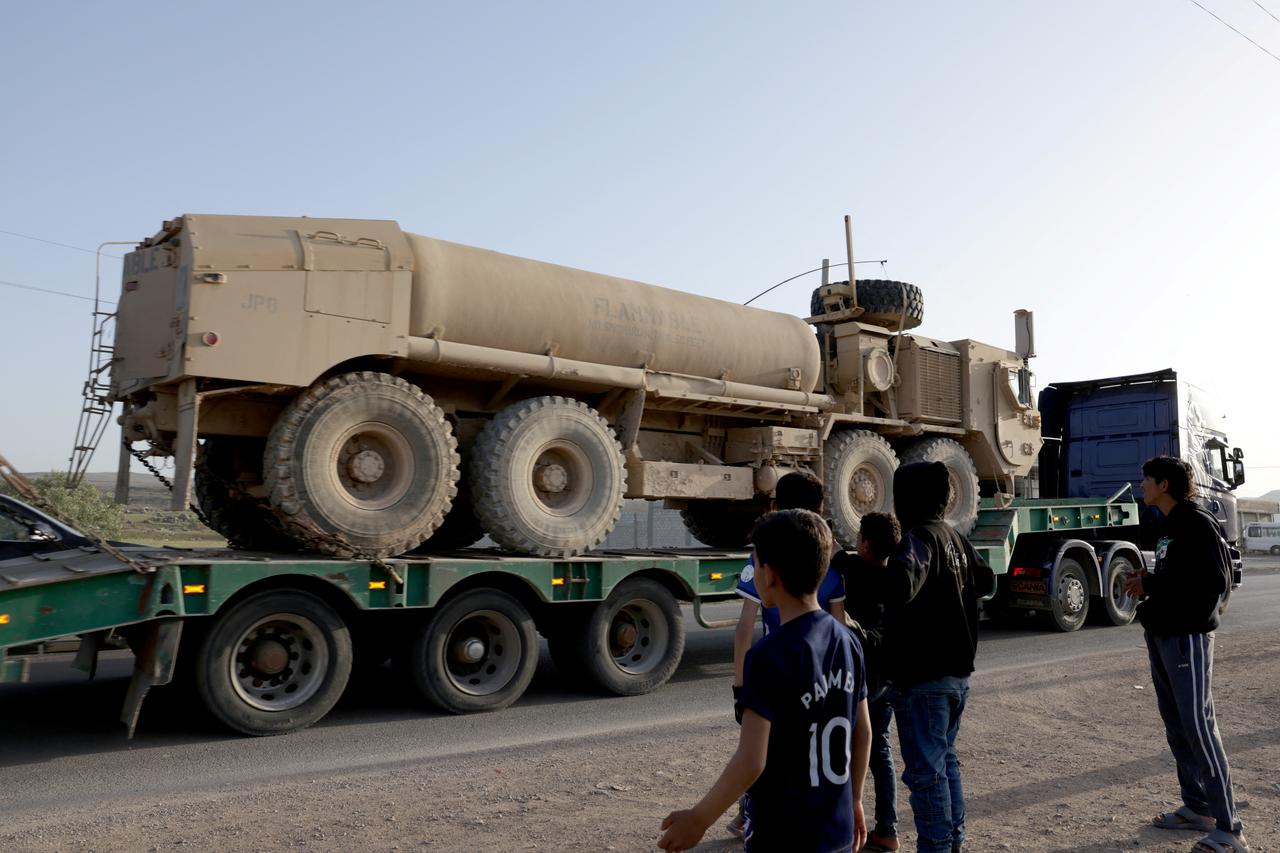 Syrian youth look on as a convoy of US military equipment is transported along the Damascus–Amman highway toward the southwestern city of Daraa, as it travels near the capital Damascus, Syria on April 16, 2026. (AFP Photo)