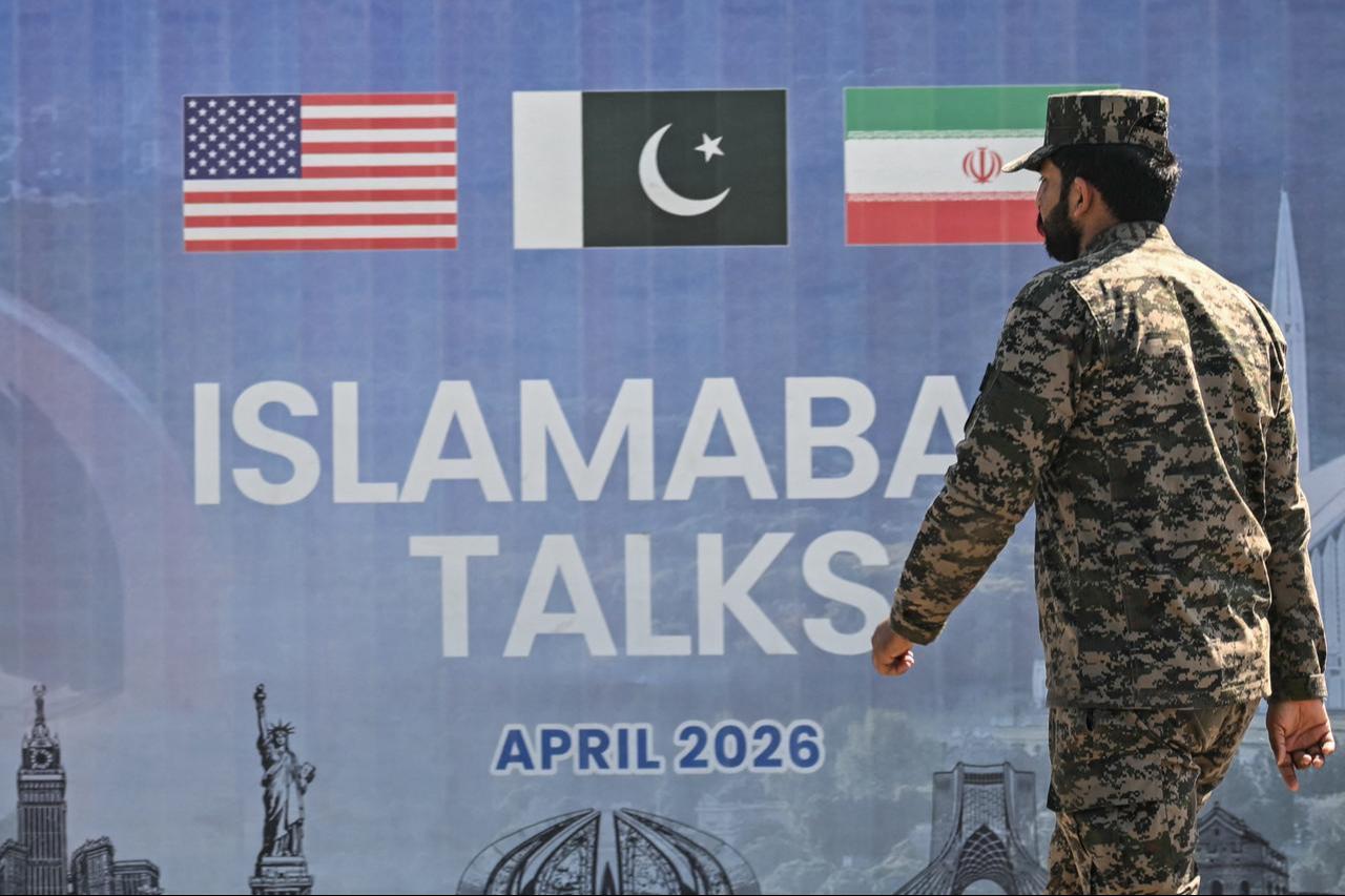 A Pakistani Ranger walks past a billboard for the US-Iran peace talks in Islamabad, Pakistan on April 12, 2026. (AFP Photo)