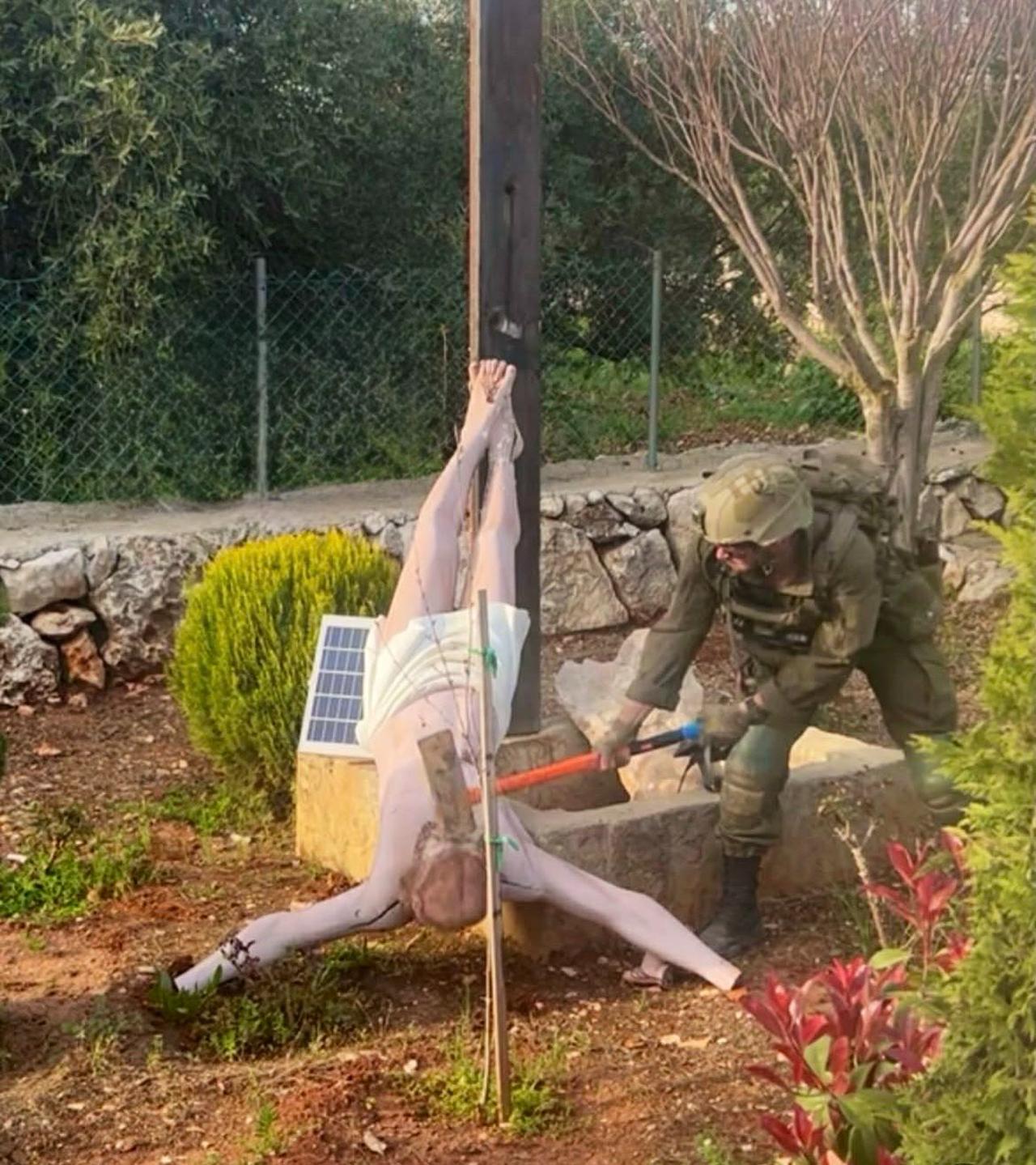 The photo shows an Israeli soldier smashing the head of a Jesus Christ statue during operations in southern Lebanon. (Photo via X/@ytirawi)
