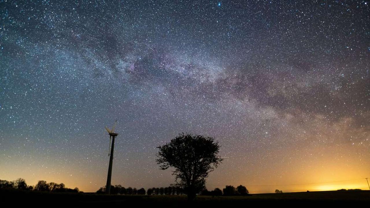 A starry sky shines above a tree and a windmill in Neukirchen, Schleswig-Holstein, Germany, April 22, 2020, during the Lyrid meteor shower. (AFP Photo)