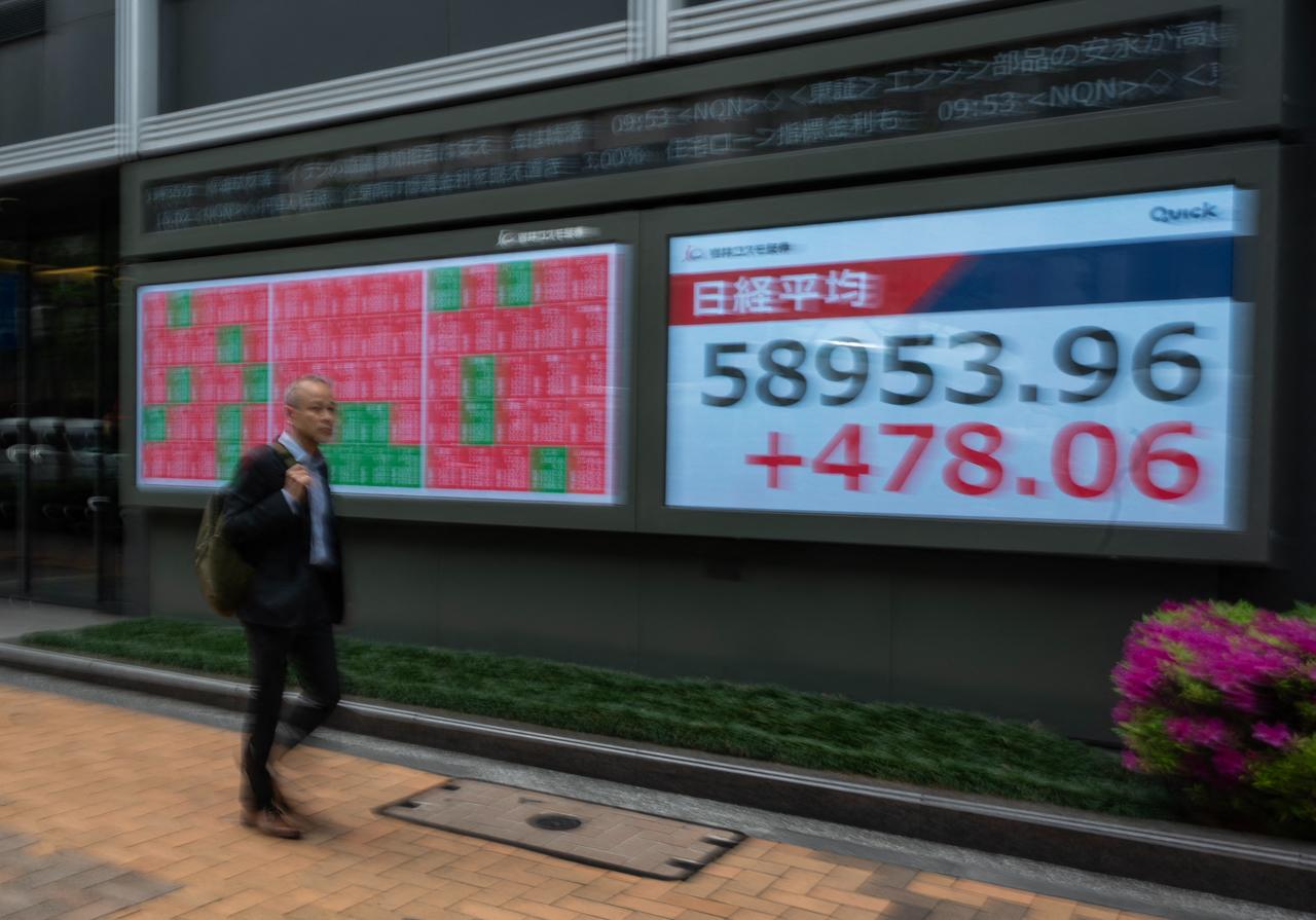 A man walks past a display of the Nikkei Stock Average near the Tokyo Stock Exchange in Tokyo, April 20, 2026. (AFP Photo)