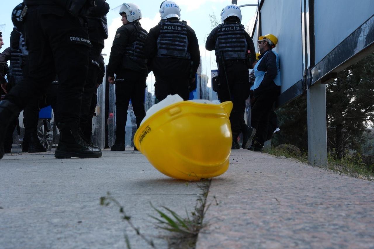 Police officers stand near detained miners as a yellow hard hat lies on the ground outside the Energy Ministry in Ankara, Türkiye, during the protest. (Photo via X/@bagimsizmadenis)