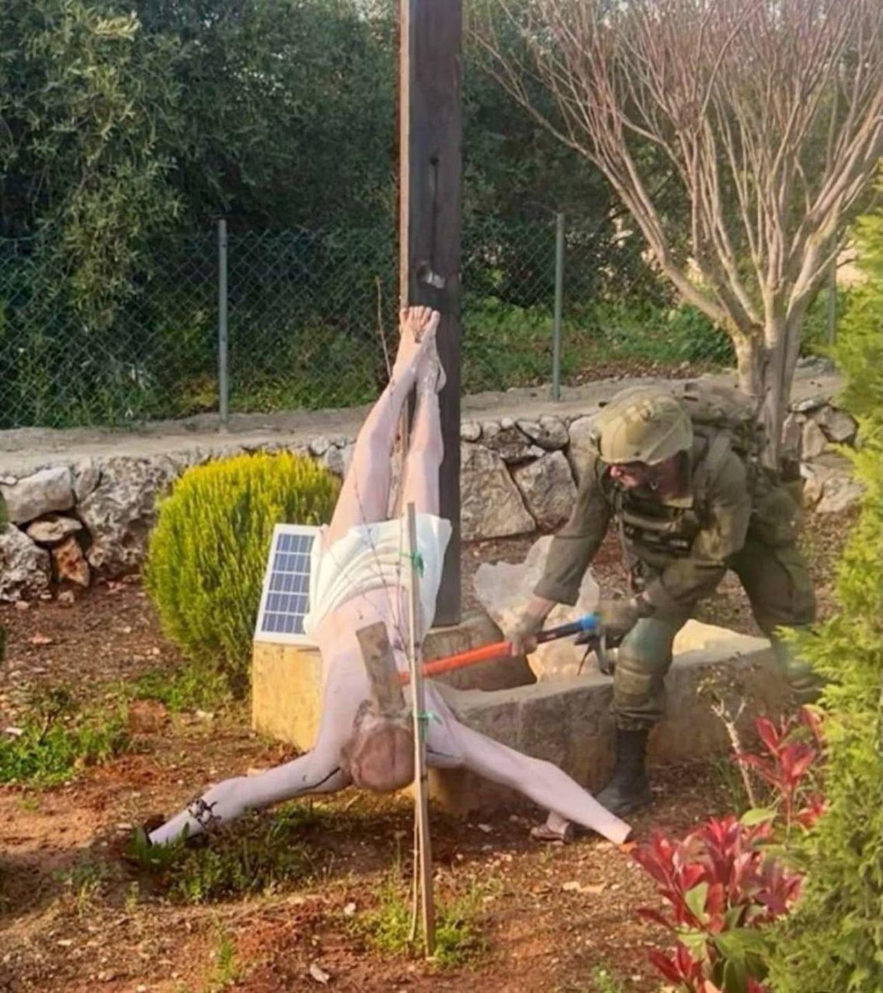 An Israeli soldier appears to damage a statue of Jesus with an axe in Deir Seryan, southern Lebanon, in an image shared on April 19, 2026. (Photo via X/@ytirawi)