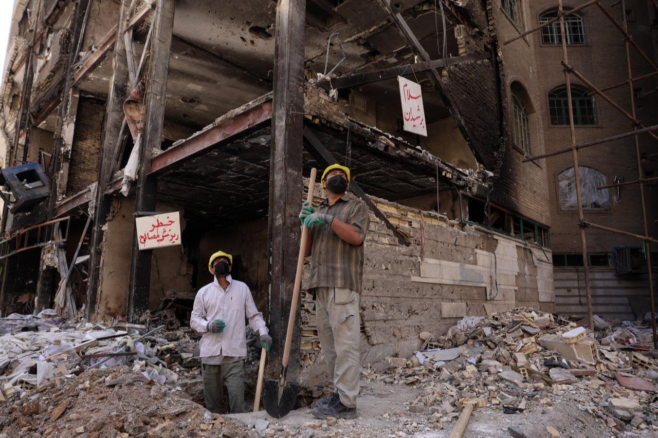 Workers look on as they stand amid the rubble of a residential building hit by US-Israel airstrikes at the Shahid Broujerdi residential complex in southern Tehran, Iran on April 14, 2026. (AFP Photo)