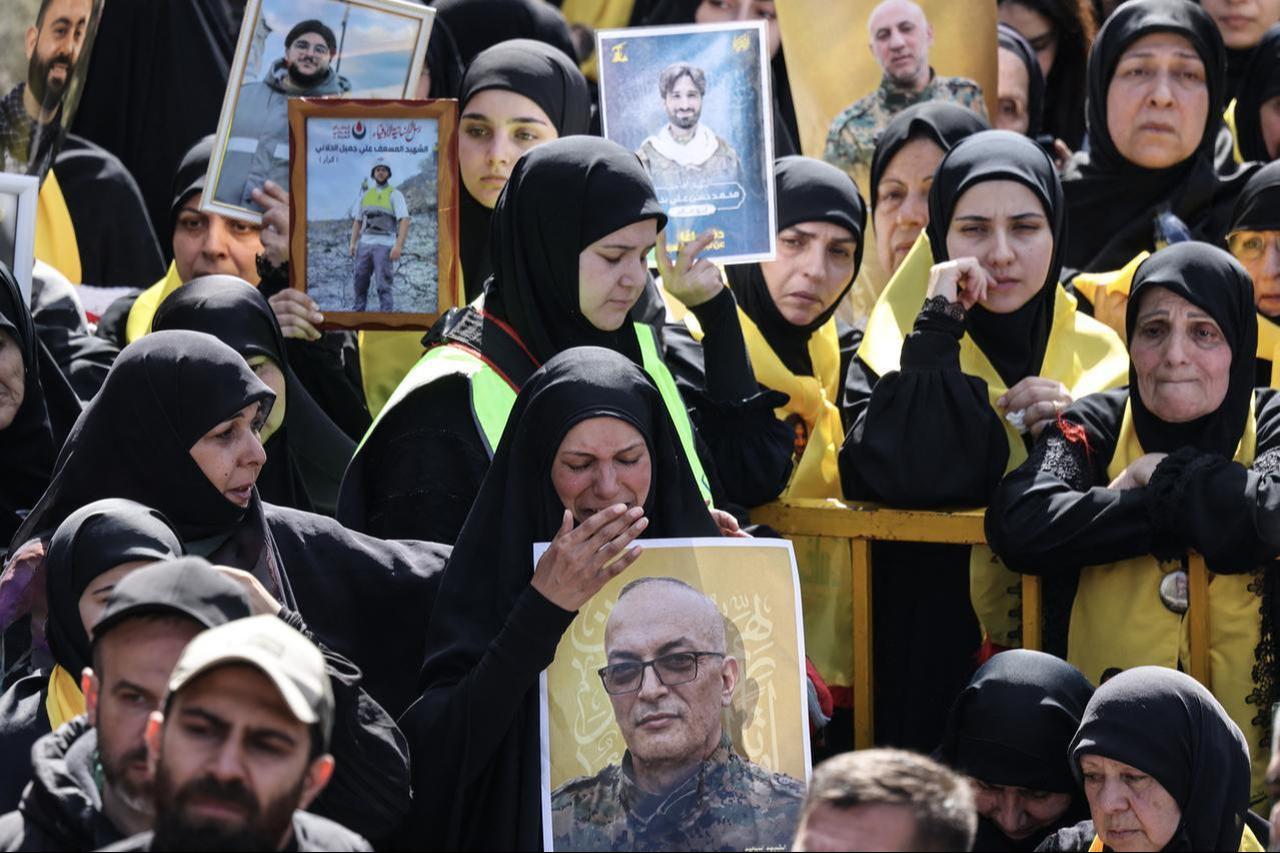 Mourners hold portraits of Hezbollah fighters killed before a 10-day ceasefire was agreed between the Iran-backed militant group and Israel during a mass funeral procession in the southern village of Kfar Sir on April 21, 2026. (AFP Photo)