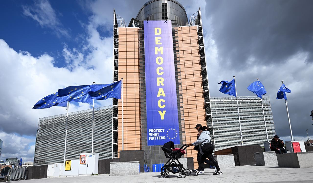 A view shows a banner reading “DEMOCRACY” displayed on the Berlaymont building, headquarters of the European Commission, in Brussels, Belgium, April 20, 2026. (AA Photo)