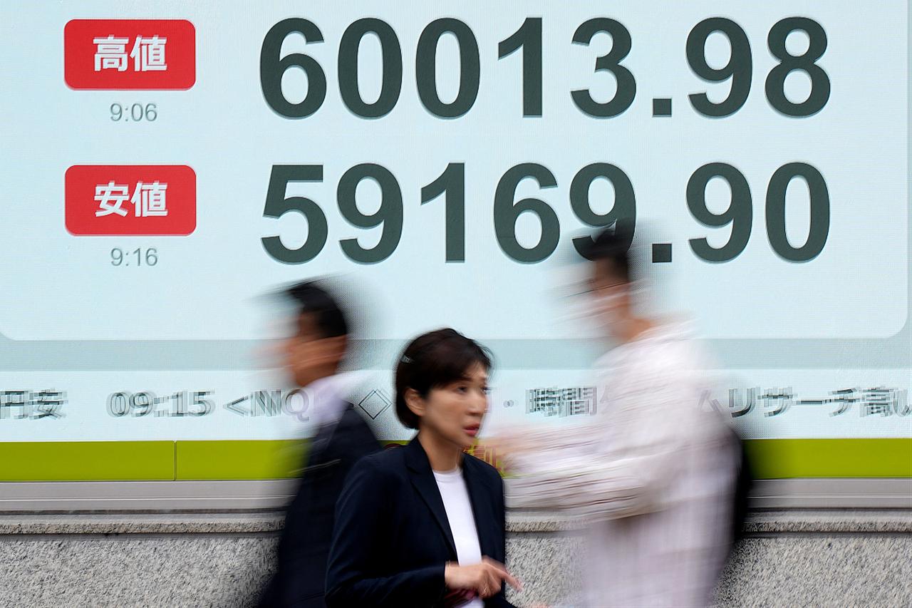 People walk past an electronic quotation board displaying the Nikkei Stock Average on the Tokyo Stock Exchange (top to bottom) highest price, and lowest price of the morning, along a street in Tokyo, April 23, 2026. (AFP Photo)