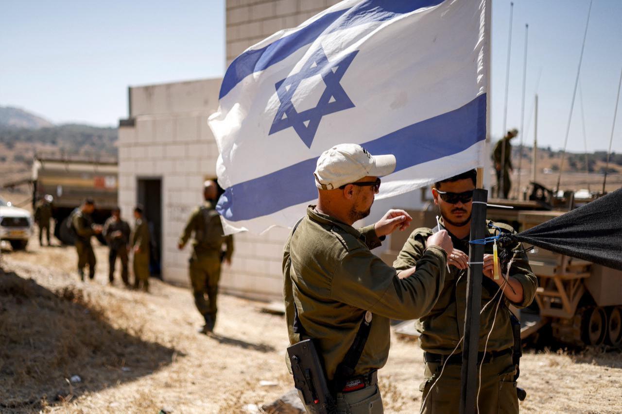 Israeli army soldiers add zip ties to the mast of an Israeli flag flying at a special area for exercises during a military drill in the Israeli-annexed Golan Heights, July 8, 2025. (AFP Photo)
