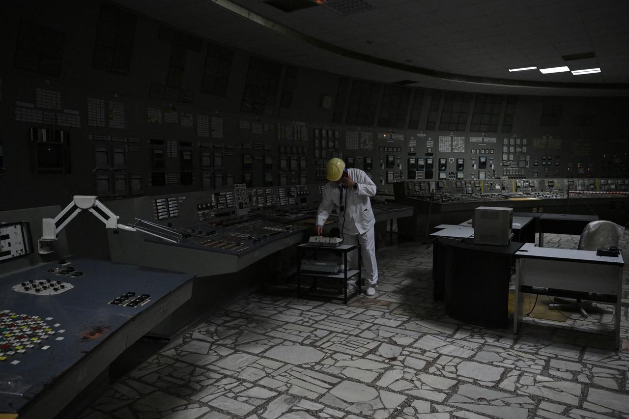Chornobyl Nuclear Power Plant deputy technical director for radioactive waste management Oleksandr Skomarokhov, uses a phone in the control room of the no longer working reactor 3 of the Chornobyl Nuclear Power Plant on April 9, 2026. (AFP Photo)