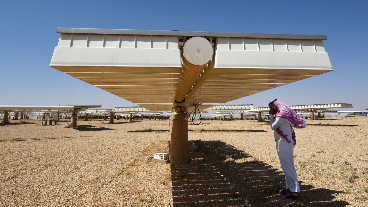 A Saudi man talks on his mobile under the shade of a solar panel at a solar plant in Uyayna, north of Riyadh, on March 29, 2018. (AFP Photo)