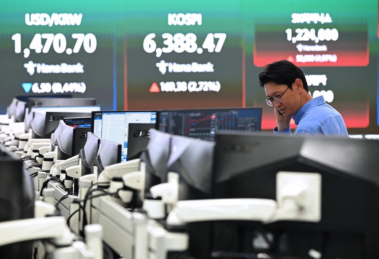 A currency dealer monitors exchange rates as a screen shows South Korea's benchmark stock index (KOSPI) and the Korean won/USD exchange rate in a foreign exchange dealing room at the Hana Bank headquarters in Seoul, April 21, 2026. (AFP Photo)