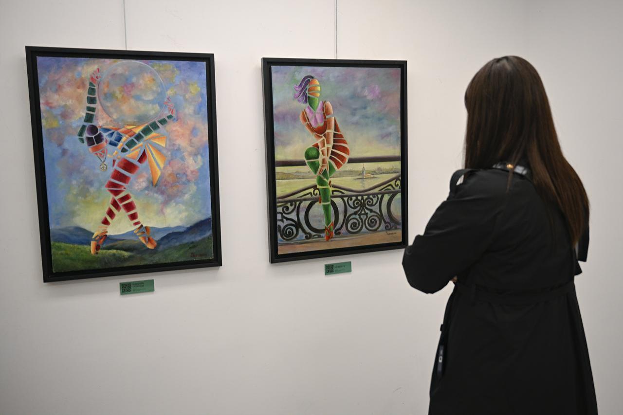 Visitor views paintings from Nazende Yucel’s “Ever-Blooming Women” exhibition, Ankara, Türkiye, April 25, 2026. (AA Photo)