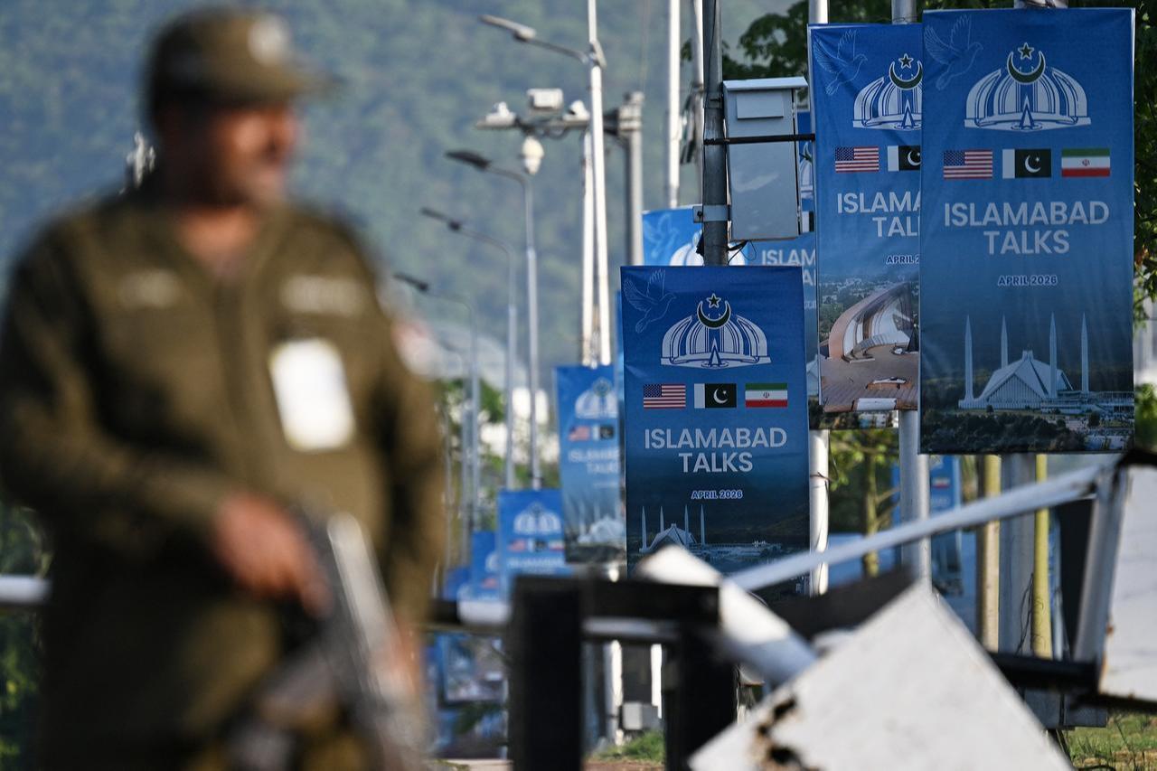 A police officer stands guard beside posters highlighting Pakistan's mediation of Iran–US peace talks near the Serena Hotel at the Red Zone area in Islamabad, April 25, 2026. (AFP Photo)
