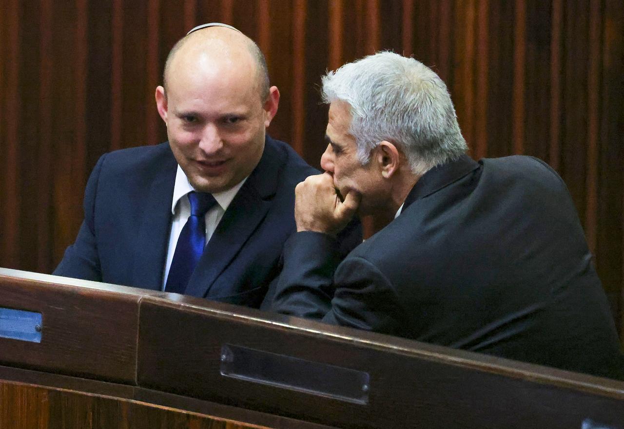 Naftali Bennett (L) and Yair Lapid (R) speaking at an unspecified location and time. (AFP Photo)