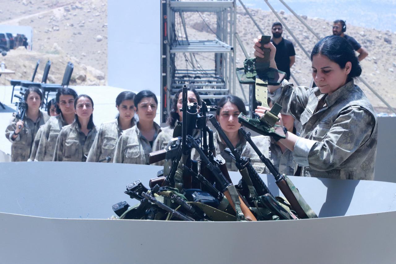 Members of the terrorist organization PKK line up to put their weapons into a pit during a ceremony in Sulaimaniyah, in Iraq, July 11, 2025. (AFP Photo)