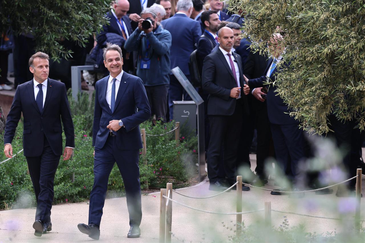 France's President Emmanuel Macron (L) and Greece's Prime Minister Kyriakos Mitsotakis visit the park at the Stavros Niarchos Foundation Cultural Center in Athens, Greece on April 25, 2026. (AFP Photo)