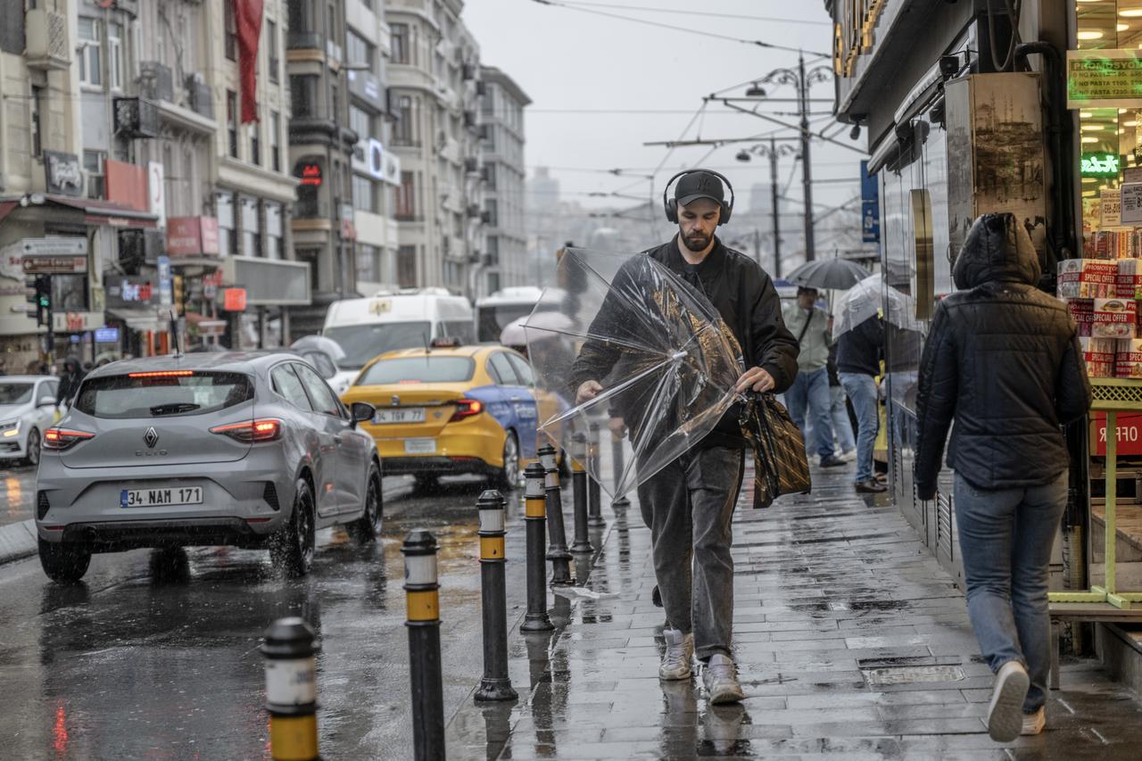 People walk under umbrellas as heavy rain hits the Eminonu district in Istanbul, Türkiye, April 22, 2026. (AA Photo)