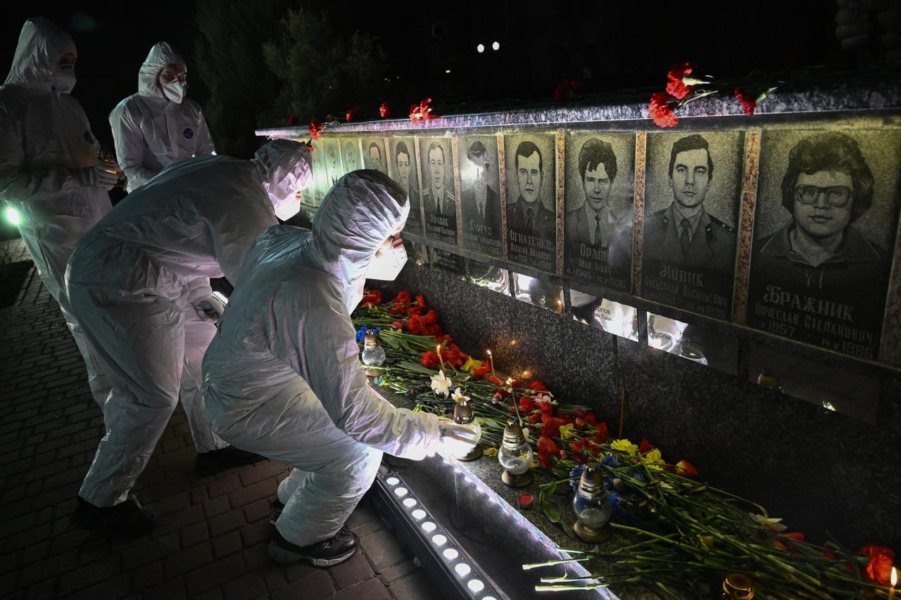 Participants dressed in white hazmat suits place candles in front of a memorial for Chernobyl victims, during a commemoration ceremony marking the 40th anniversary, in the town of Slavutych, Ukraine on April 26, 2026. (AFP Photo)