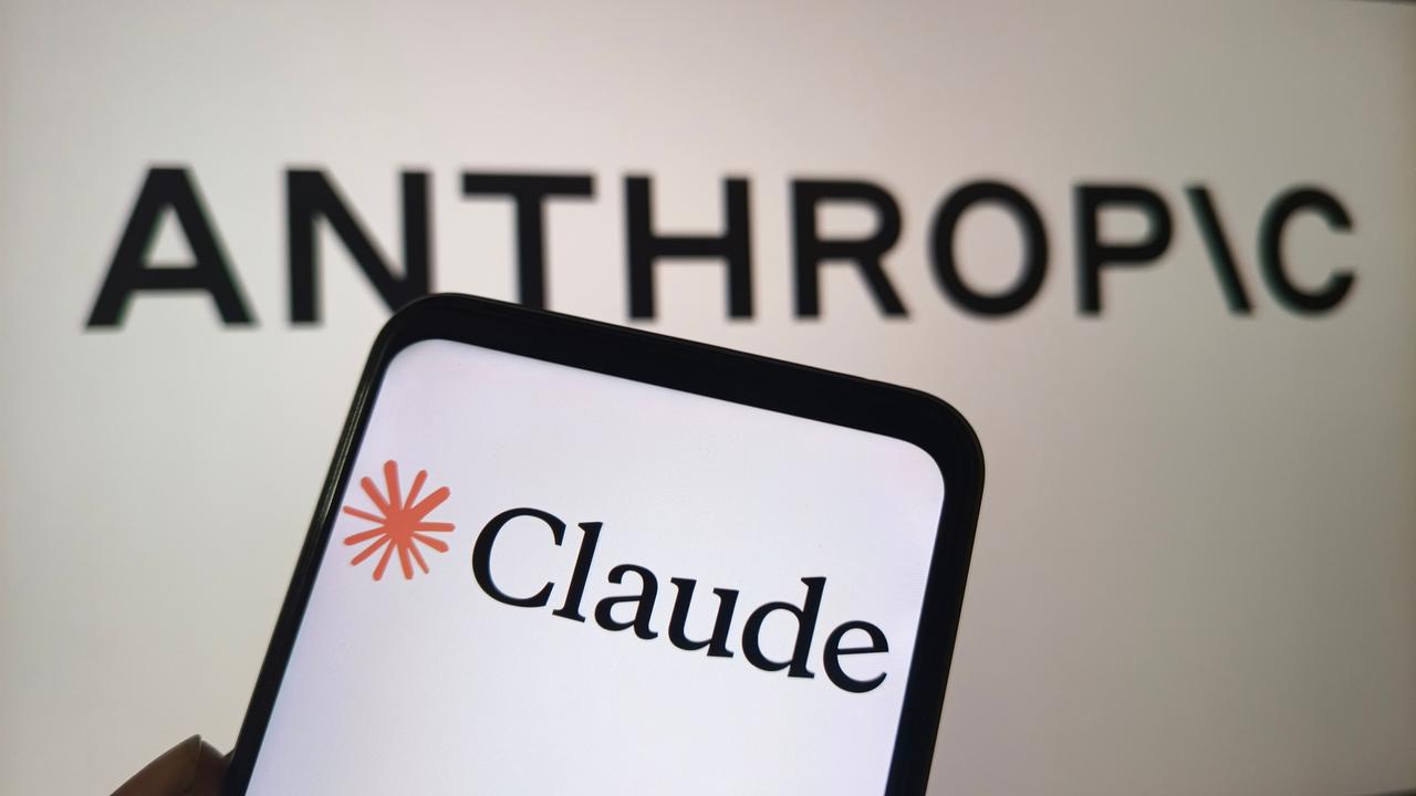 The Claude logo is displayed on a smartphone screen with the Anthropic wordmark in the background (Adobe Stock Photo)