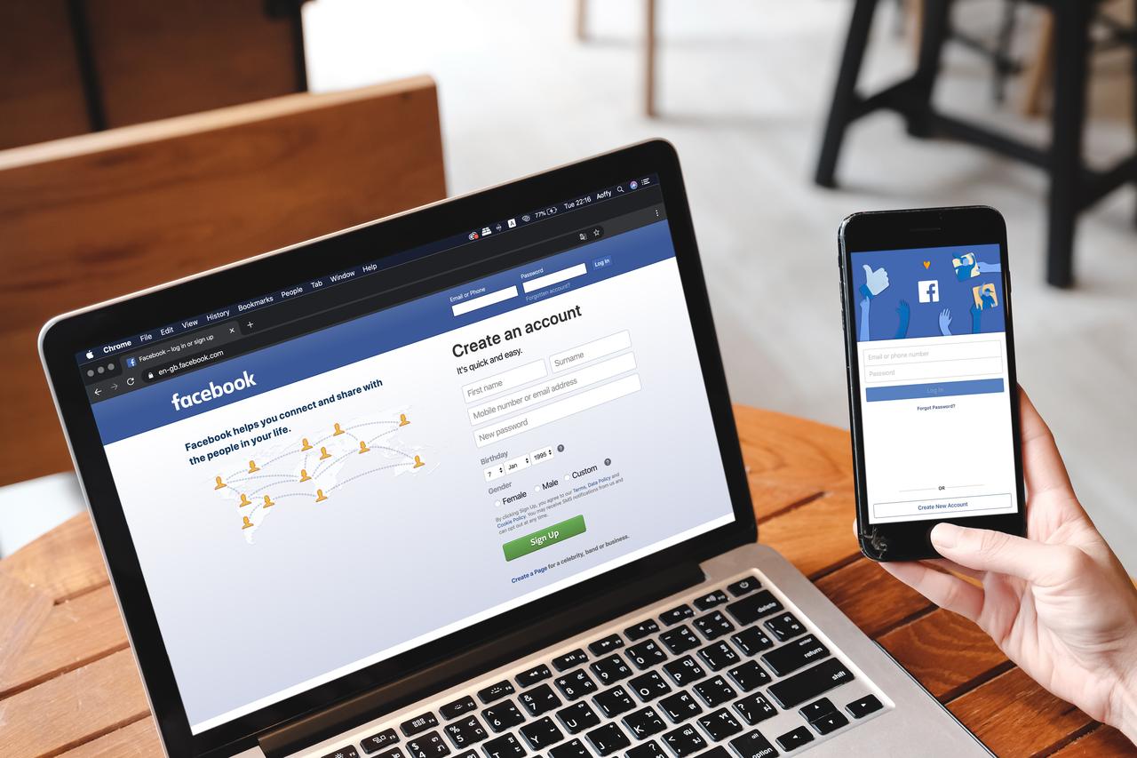 The Facebook login and account creation page is displayed on a laptop and smartphone (Adobe Stock Photo)
