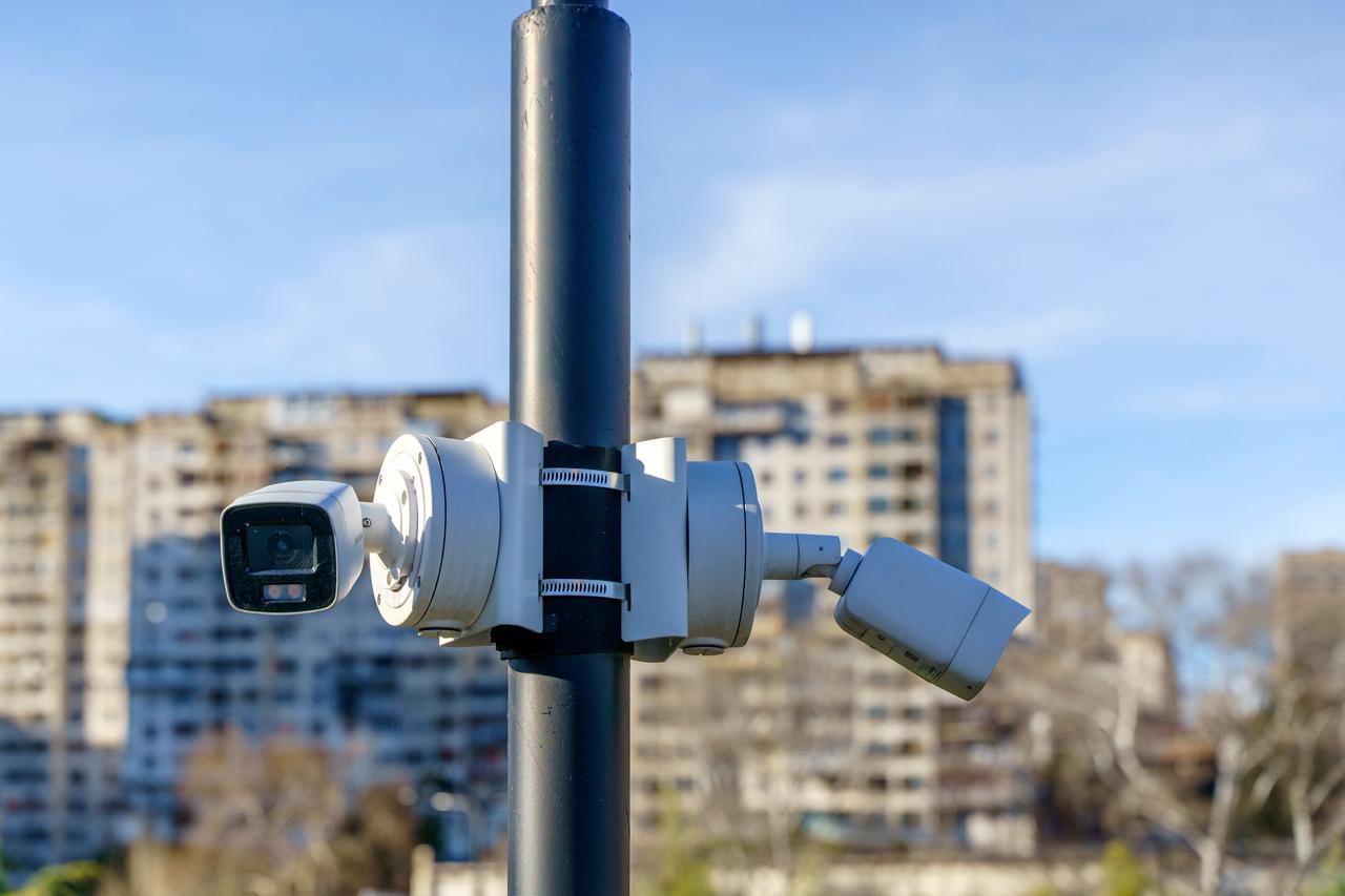 Surveillance cameras are mounted on a pole in an urban area (Adobe Stock Photo)