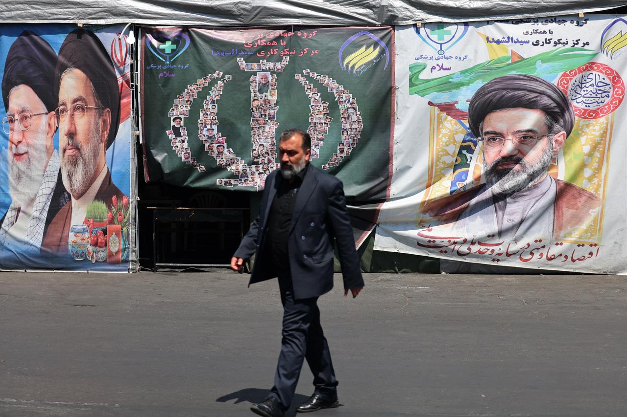 A man walks past banners installed along the roadside of Iran's slain supreme leader Ali Khamenei (L) and of supreme leader Mojtaba Khamenei, in Tehran, Iran, April 29, 2026. (AFP Photo)