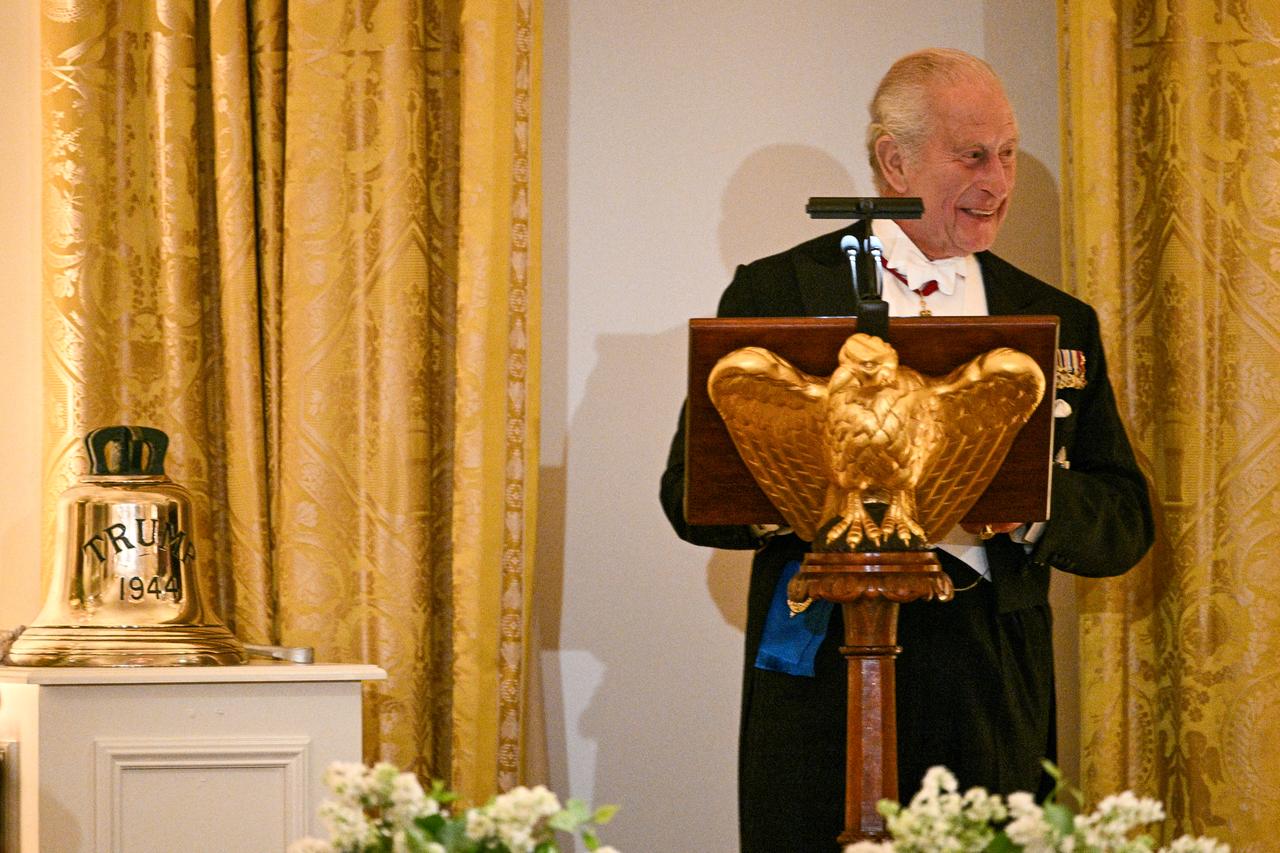 Britain's King Charles III presents the original bell from the H.M.S. Trump, a World War II-era submarine and inscribed "Trump 1944", as a gift to US President Donald Trump (out of frame) during a State Dinner in the East Room of the White House in Washington, DC, April 28, 2026. (AFP Photo)