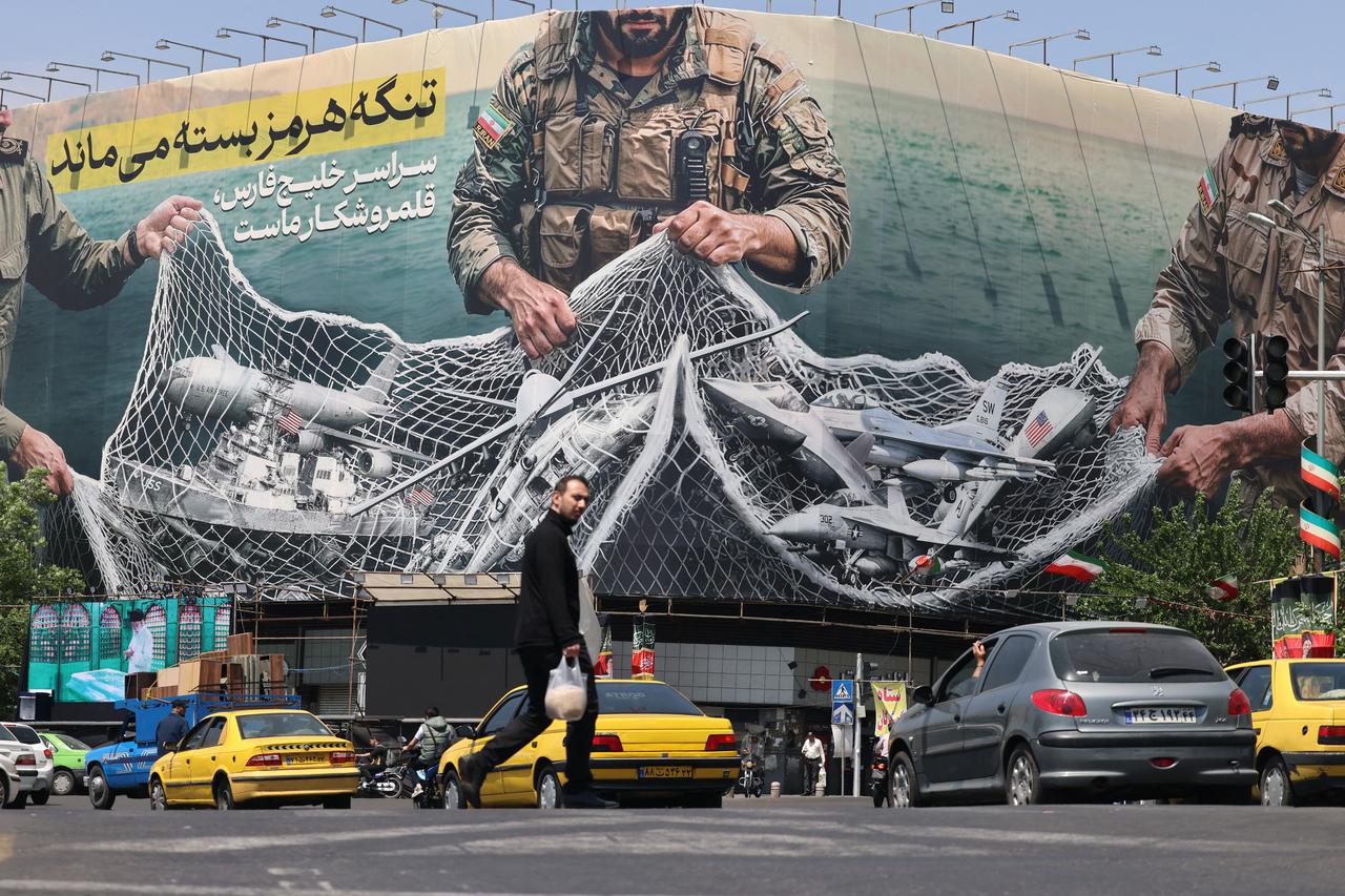 Vehicles drive past a giant billboard reading 'The Strait of Hormuz remains closed' at the Revolution Square in Tehran, Iran, April 28, 2026. (AFP Photo)